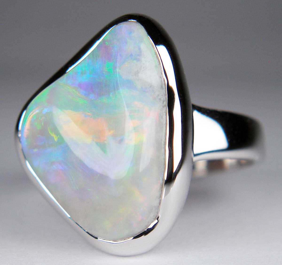 Solid carved light crystal opal ring in 18ct white gold