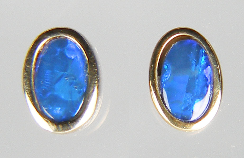 Tiny blue opal doublet earstuds in 9ct yellow gold